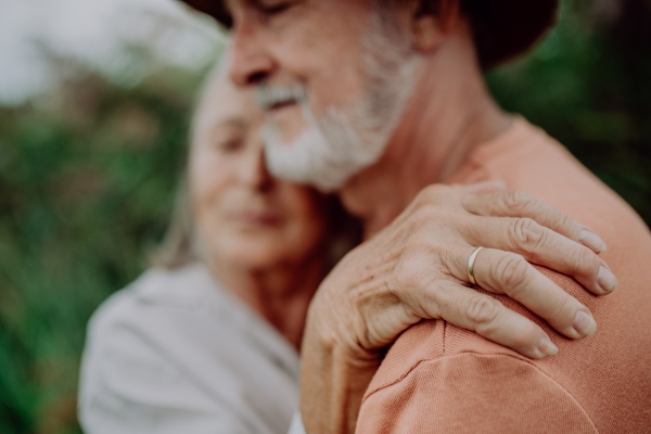 Portrait of senior couple in love, standing and hugging outdoor in the nature.