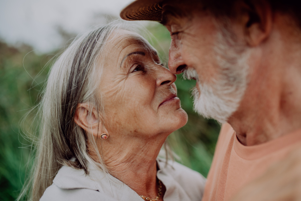 Portrait of senior couple in love, standing and hugging outdoor in the nature.