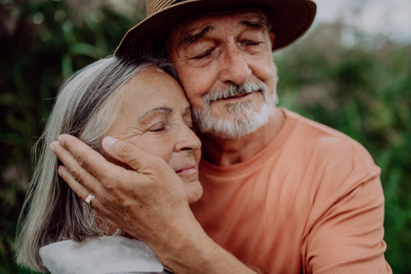 Portrait of senior couple in love, standing and hugging outdoor in the nature.