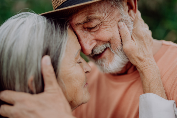 Portrait of senior couple in love, standing and hugging outdoor in the nature.