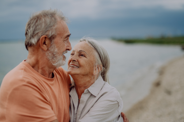 Senior couple relaxing and having romantic moment at the autumn sea.