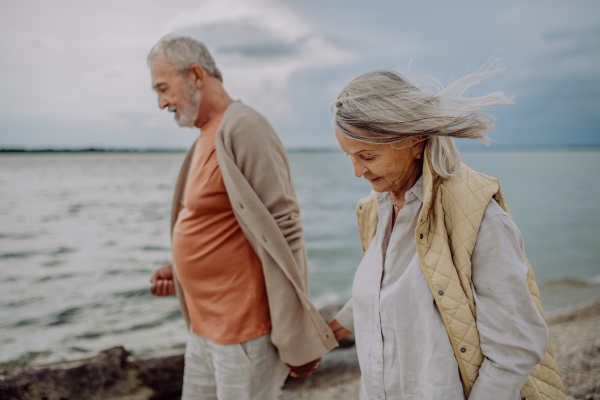 Senior couple relaxing and having romantic moment at the autumn sea.