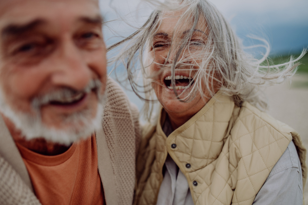 Happy senior couple relaxing and having romantic moment at the autumn sea.