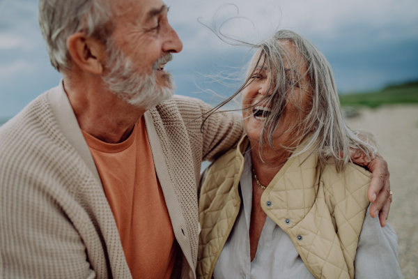 Happy senior couple relaxing and having romantic moment at the autumn sea.