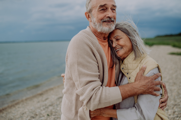 Portrait of senior couple in love, standing and hugging outdoor in the nature.