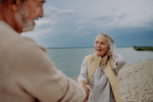 Happy senior couple relaxing and having romantic moment at the autumn sea.