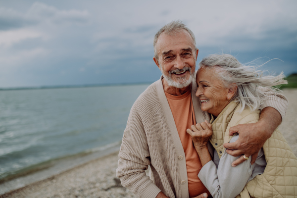 Senior couple relaxing and having romantic moment at the autumn sea.