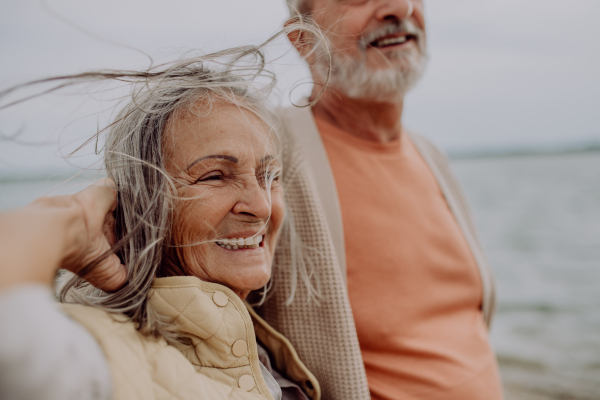 Happy senior couple relaxing and having romantic moment at the autumn sea.