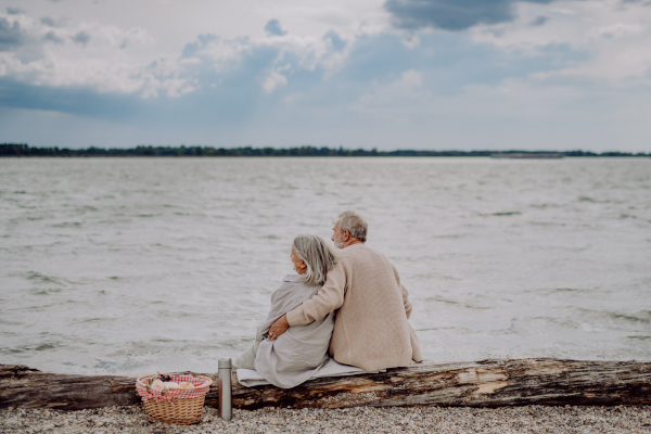 Senior couple relaxing and looking at autumn ocean.