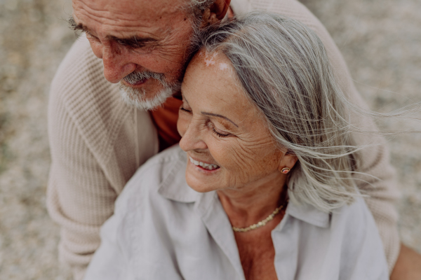 Senior couple relaxing and having romantic moment at the autumn sea.