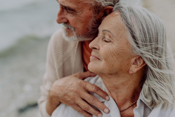 Happy senior couple relaxing and having romantic moment at the autumn sea.