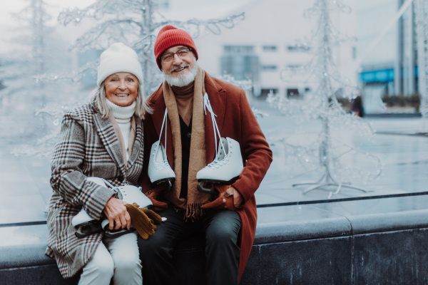 Portrait of seniors in winter at an outdoor ice skating rink.