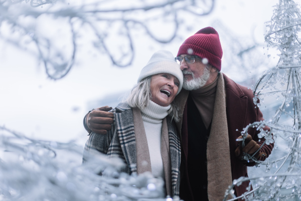 Senior couple walking in a winter city center. Elegant senior spouses enjoying walk during cold winter day.