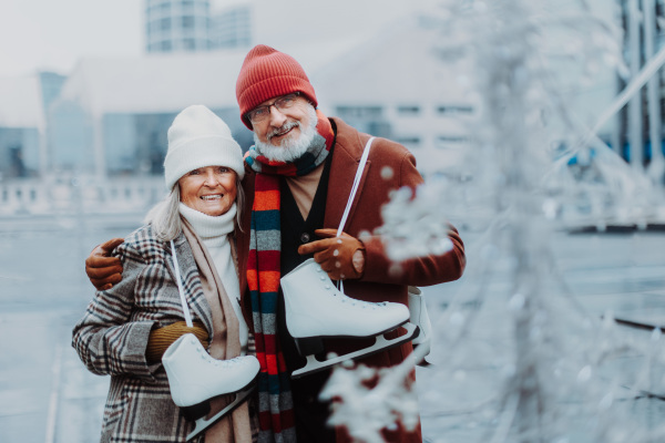 Portrait of seniors in winter at an outdoor ice skating rink.