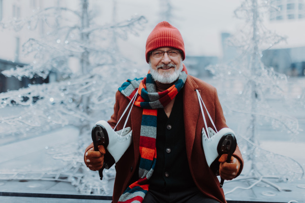 Portrait of happy senior man in winter at an outdoor ice skating rink.