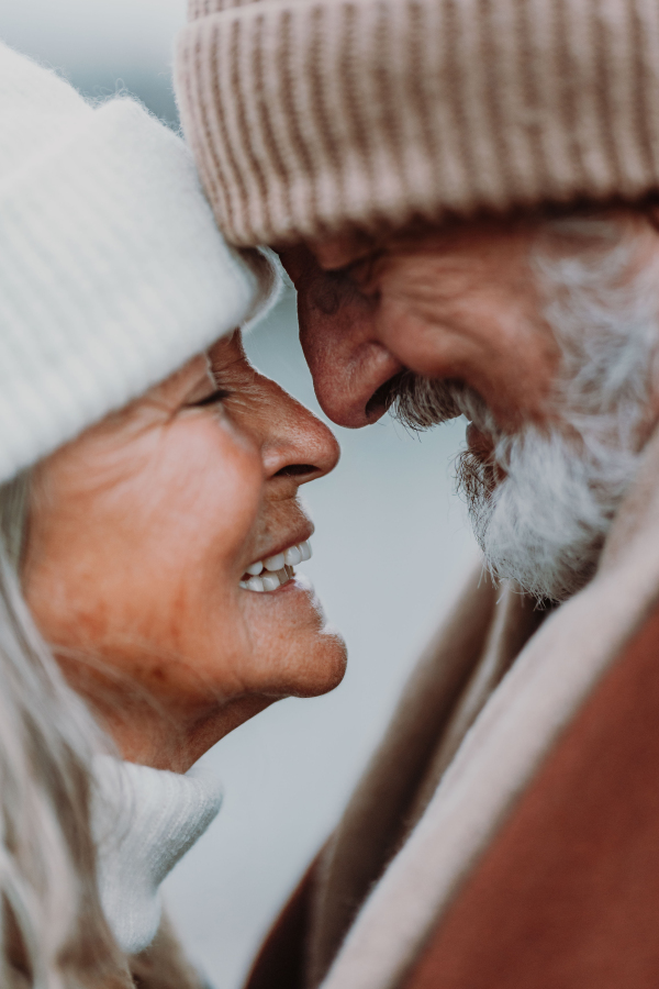 Close up portrait of seniors in winter Christmas day. Smiling, embracing each other.