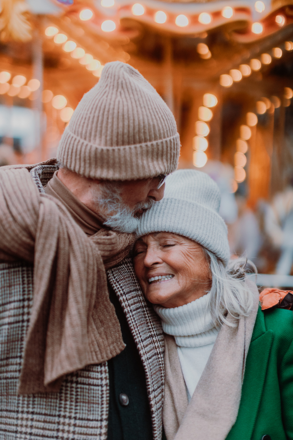 Close up portrait of seniors in winter Christmas day. Smiling, embracing each other.