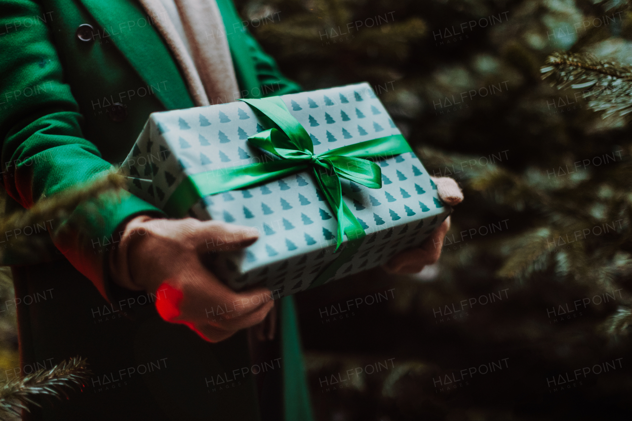 Close-up of woman holding the gifts, outdoor at Christmas market.