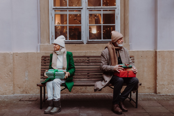 Offended senior couple citting on a city bench.