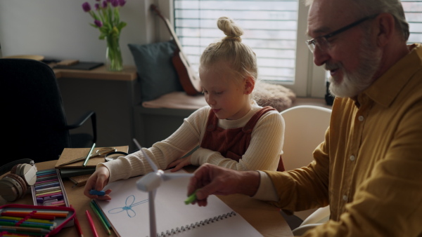 Senior man studying with his granddaughter.