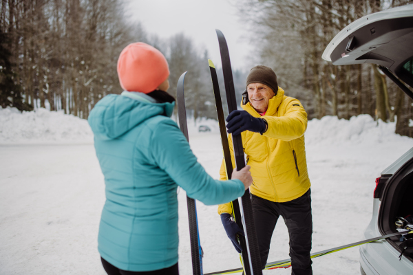 Happy senior woman preparing for skiing with her husband.