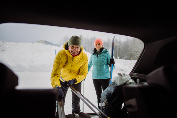 Happy senior woman preparing for skiing with her husband.