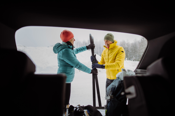 Happy senior woman preparing for skiing with her husband.