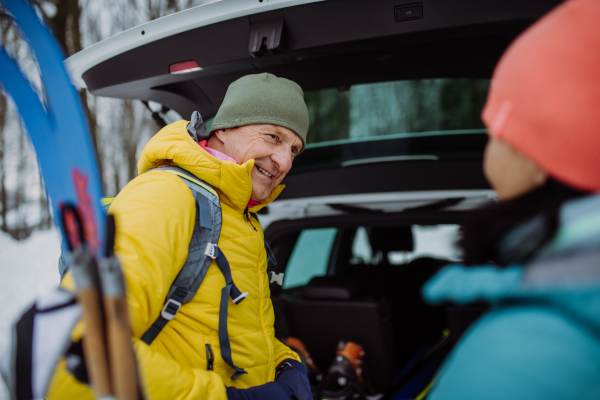 Happy senior woman preparing for skiing with her husband.