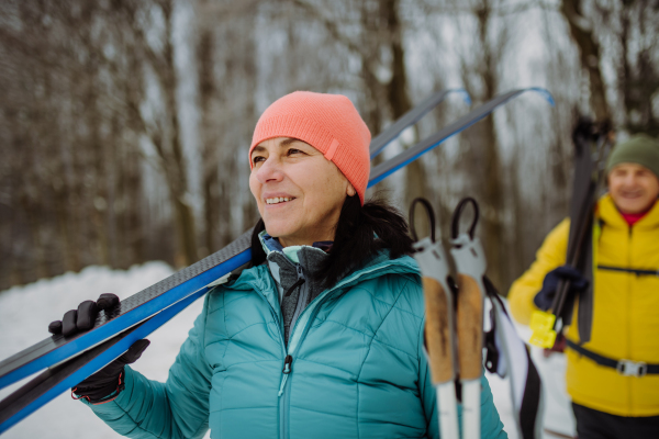 Happy senior woman preparing for skiing with her husband.