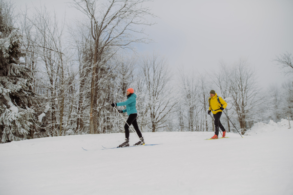 Senior couple skiing togetherin the middle of snowy forest