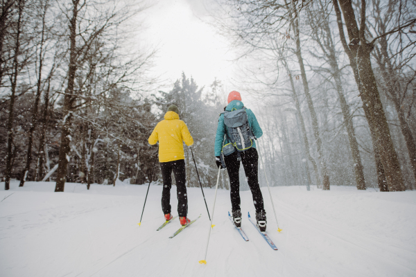 Senior couple skiing togetherin the middle of snowy forest