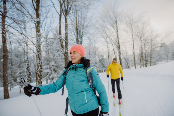 Senior couple skiing togetherin the middle of snowy forest