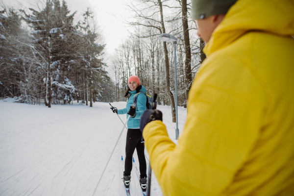 Senior couple skiing togetherin the middle of snowy forest