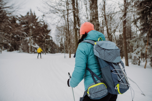 Senior couple skiing together in the middle of snowy forest