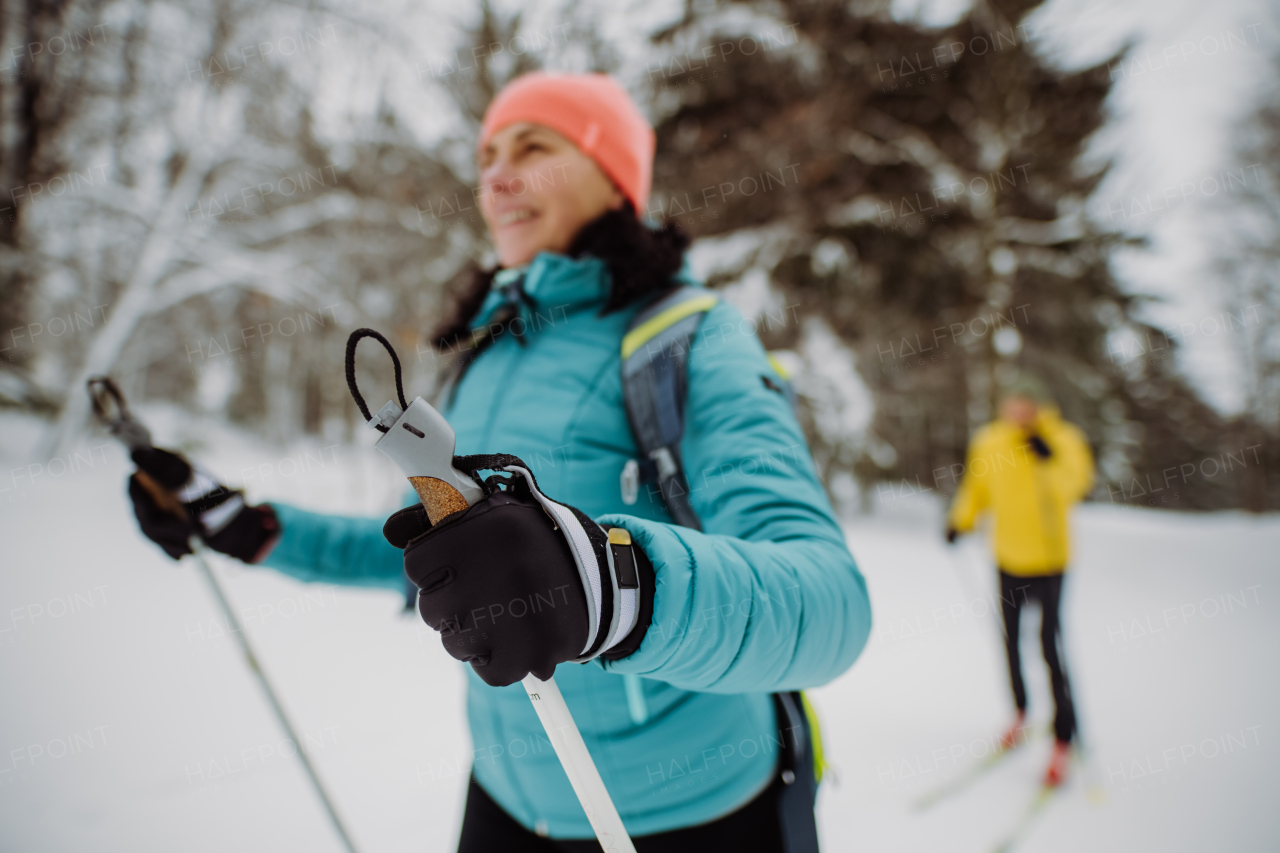 Senior couple skiing together in the middle of snowy forest