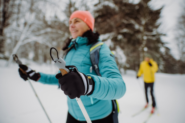 Senior couple skiing together in the middle of snowy forest