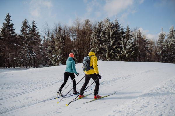 Senior couple skiing togetherin the middle of snowy forest