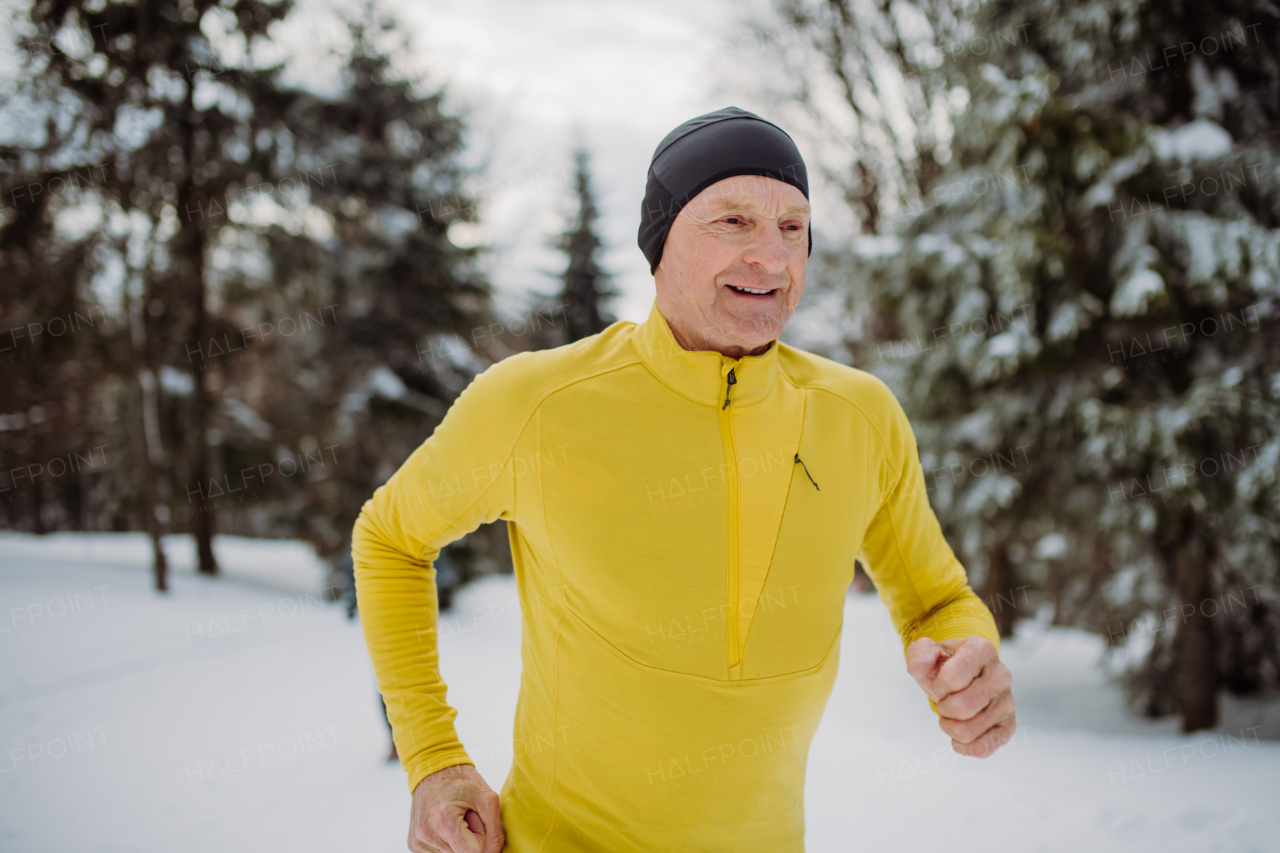 Senior man solo jogging in winter nature.