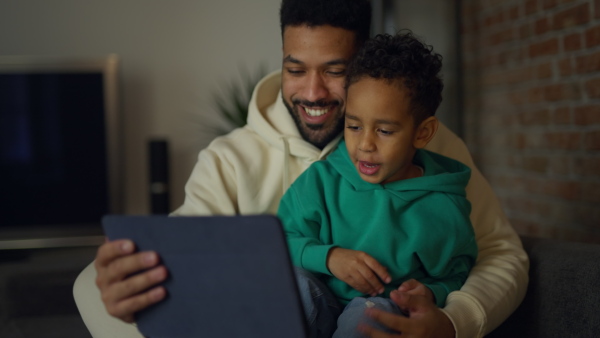 Young father with his son having a call on digital tablet, enjoying time together.