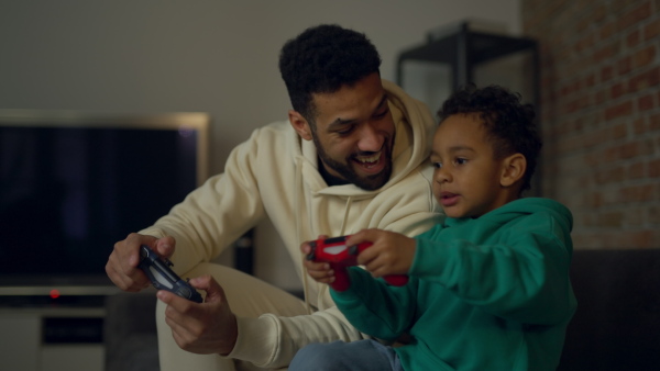 Young father with his playing on video console, enjoying time together.