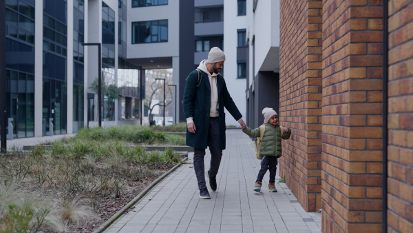 Young father and his little son during outdoor walk in a city.