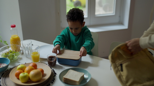 Young father and his little son having breakfast together in their flat.