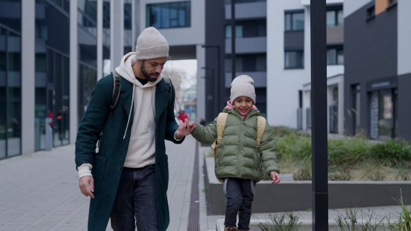 Young father and his little son during outdoor walk in a city.