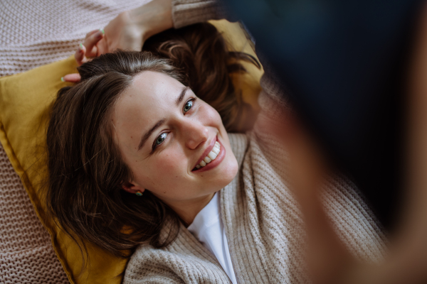 Young woman taking selfie, enjoying time alone in the apartment.