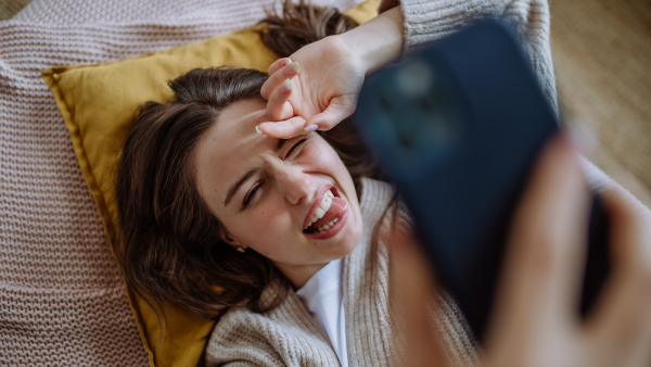 Young woman taking selfie, enjoying time alone in the apartment.