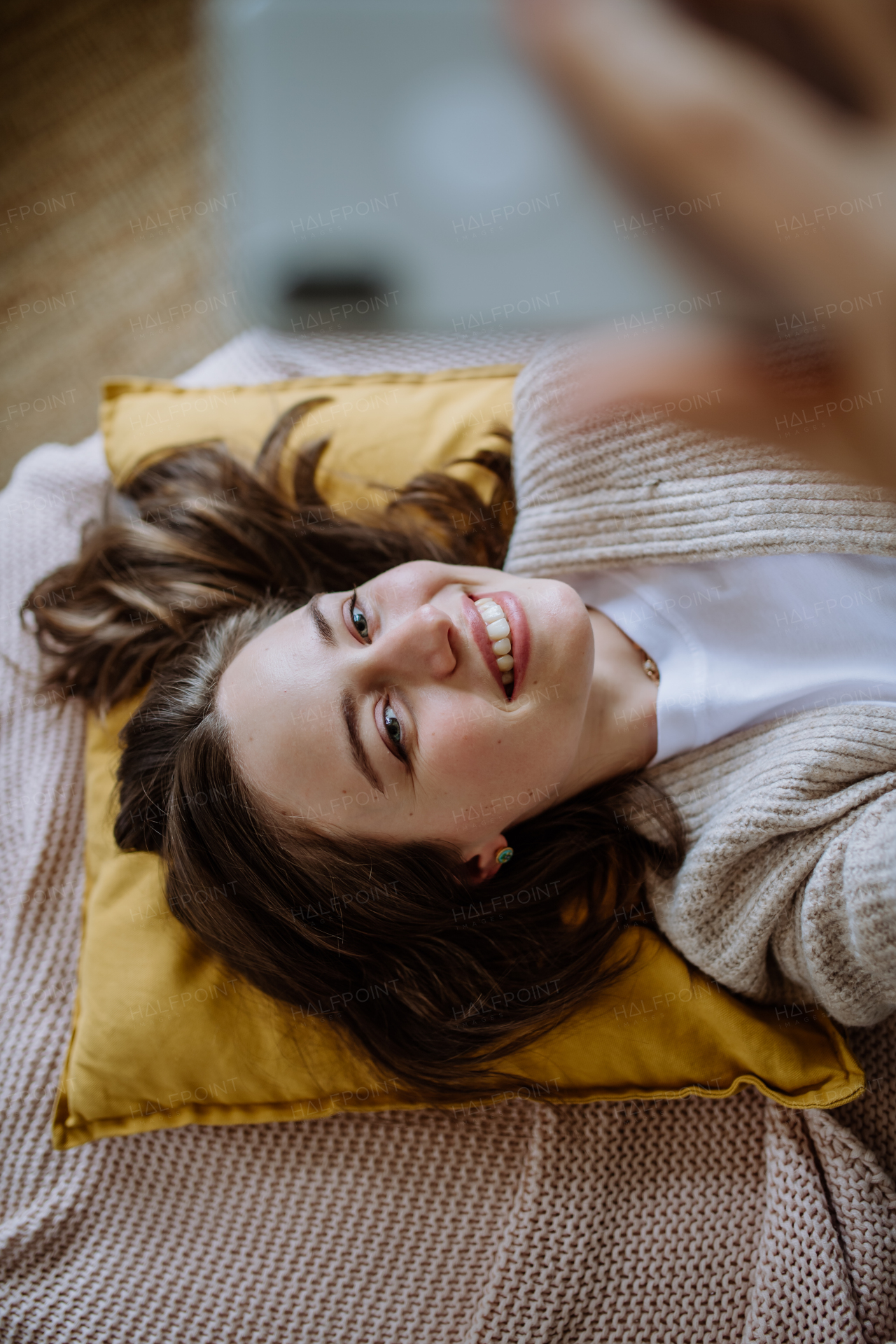 Young woman taking selfie, enjoying time alone in the apartment.