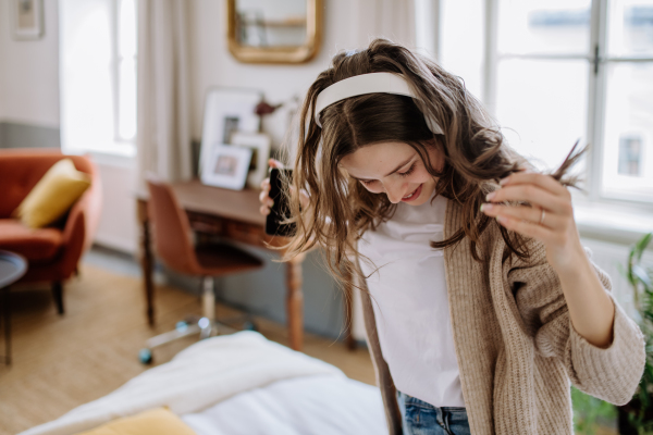 Young woman listening music trough headphones in the apartment.