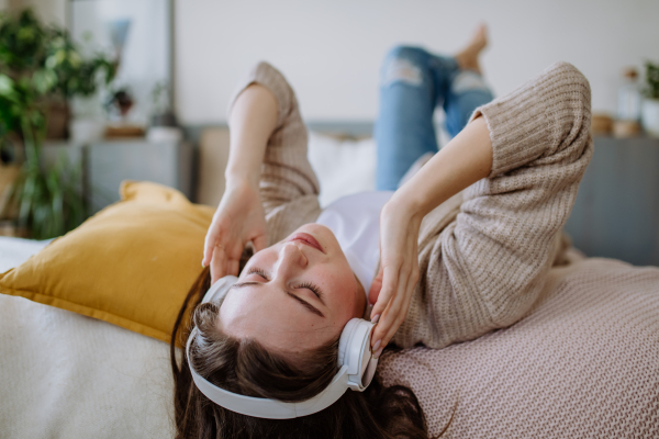 High angle view of young woman listening music trough a headphones.