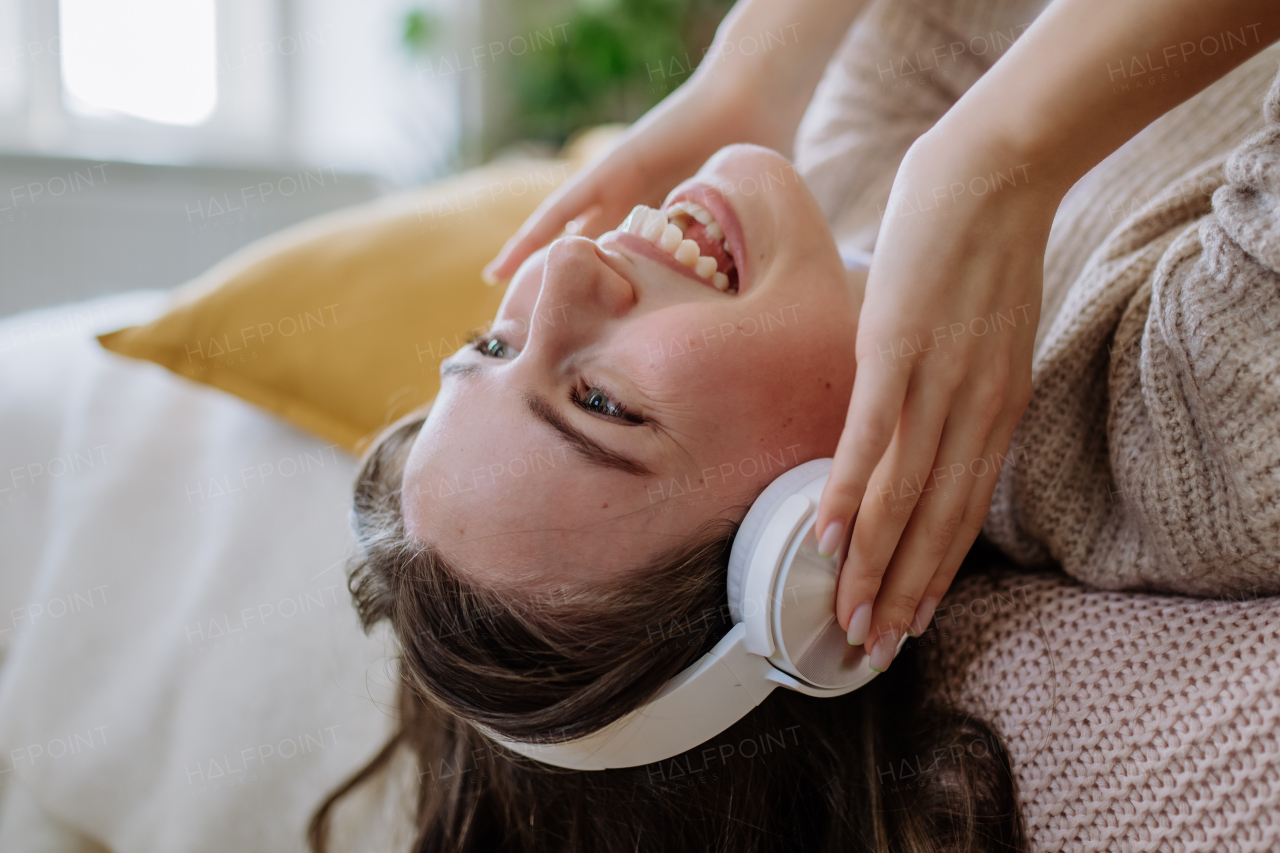 Young woman listening music trough headphones in the apartment.