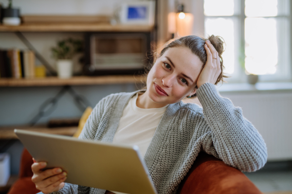 Young woman with digital tablet resting in the apartment.